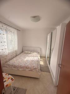 a small bedroom with a bed and a window at Apartman Danilo i Filip in Risan