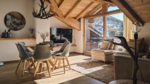 a living room with a table and chairs at Silva: The Alpine Chalet in Livigno