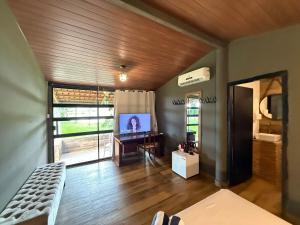 a living room with a couch and a television at SUITE na margem do lago in Hidrolândia