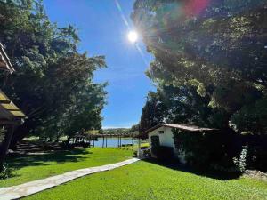a house in a yard with a view of the water at SUITE na margem do lago in Hidrolândia