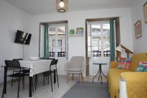 a living room with a table and a yellow couch at Casa do jato in Muros +14 photos