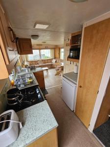 an rv kitchen and living room with a stove at Ingoldmells golden sands plot 152 in Ingoldmells