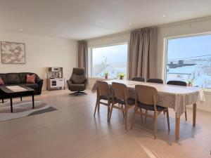 a living room with a table and chairs and a couch at apartment With fantastic view and parking in Tromsø +22 photos