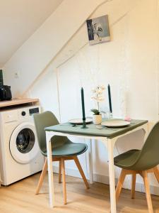 a table and chairs in a kitchen with a washing machine at greenhouse home in Corbeil-Essonnes