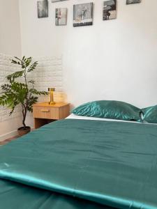 a green bed in a bedroom with a potted plant at greenhouse home in Corbeil-Essonnes
