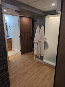 a room with robes hanging on a wall and a door at Spacious King Pull Out Suite Beamsville in Beamsville