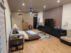 a living room with a bed and a couch and a tv at Spacious King Pull Out Suite Beamsville in Beamsville