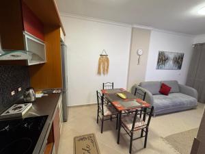 a kitchen and living room with a table and a couch at Teddy Apartment in Durrës