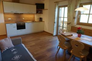 a kitchen and living room with a table and a couch at Niederhaushof in Santa Valpurga