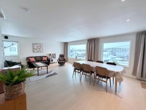 a large living room with a table and chairs at apartment With fantastic view and parking in Tromsø