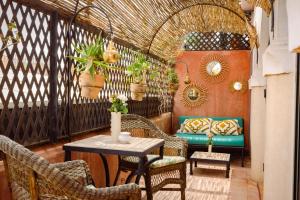 a patio with chairs and a table and a couch at Riad Dar Al Assad in Marrakesh