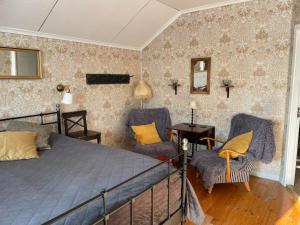 a bedroom with a bed and two chairs at Granbo station in Granbo