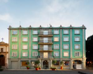 a large green building with balconies on a street at Hotel Marques Del Valle in Oaxaca City