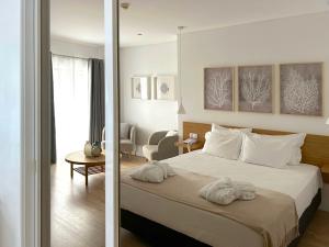 ein Schlafzimmer mit einem Bett, auf dem Handtücher liegen in der Unterkunft Hotel Solaris in Setúbal