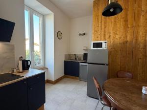 a small kitchen with a table and a refrigerator at Le Clair-Obscur in Paray-le-Monial