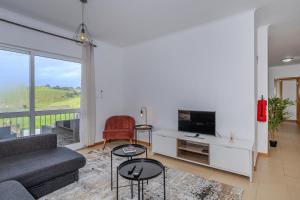 a living room with a couch and a tv at Azorina Lodge in Ponta Delgada