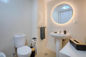 a white bathroom with a toilet and a sink at Azorina Lodge in Ponta Delgada +28 photos