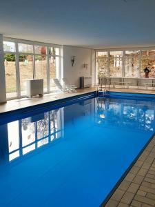 a large swimming pool with blue water in a building at FeWo Hänsel in Schönwald +5 photos