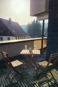 a wooden table and two chairs on a patio at FeWo Hänsel in Schönwald