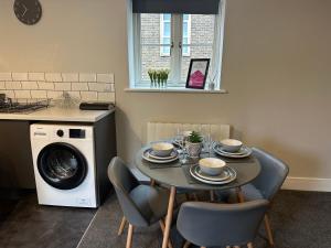 a kitchen with a table and chairs and a washing machine at Maple House by ShortStays4U A beautiful 2Bedroom House with free parking in town centre! in King's Lynn