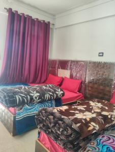 a living room with three beds and a couch at Balaji hotel in Badrinath +5 photos