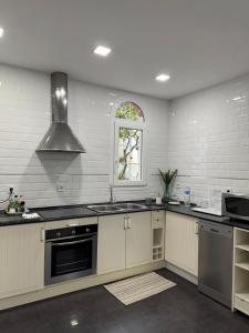 a kitchen with white cabinets and a sink and a window at Despertar in Antequera