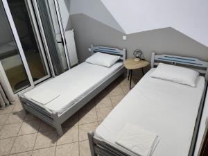 two beds in a small room with a table at liogerma i in Agios Ioannis Kaspaka