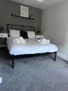 a bedroom with a bed with white sheets and pillows at Maple House by ShortStays4U A beautiful 2Bedroom House with free parking in town centre! in King's Lynn