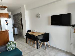 a kitchen with a table and chairs and a television on a wall at liogerma i in Agios Ioannis Kaspaka