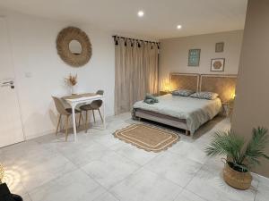 a bedroom with a bed and a table and a desk at Studio indépendant a 20min des plages in Castelnau-de-Guers