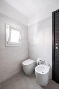 a white bathroom with a toilet and a sink at Piccola dimora Casalecchio vicino al GranReno e Unipol in Zola Predosa +6 photos
