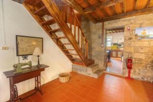 a room with a wooden staircase and a stone wall at Entre a Pedra e o Mar in Faial da Terra