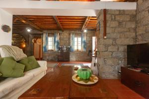 a living room with a couch and a stone wall at Entre a Pedra e o Mar in Faial da Terra
