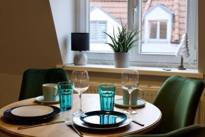 a table with glasses and plates on it with a window at Sehr gemütlich und modern in Haldensleben