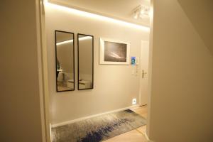 a hallway with three mirrors on a wall at Sehr gemütlich und modern in Haldensleben +9 photos