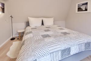 a bedroom with a bed with a blue and white comforter at Sehr gemütlich und modern in Haldensleben