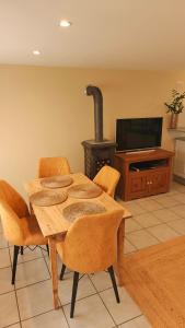 a dining room with a table with chairs and a stove at L'orée du vignoble in Vaux-en-Beaujolais