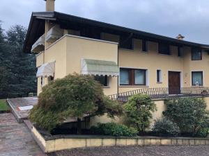 a large yellow house with trees in front of it at Dream's hill in San Pietro di Feletto
