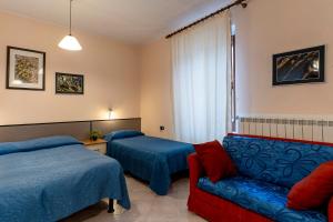 a hotel room with two beds and a couch at Bed and Breakfast L'Annunziata in Sulmona