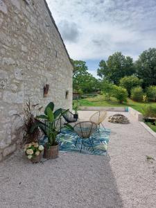 a patio with a table and chairs next to a building at La Maison d'ART in Lacour