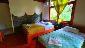 a bedroom with two beds and a window at Rio Napo Lodge in Puerto Misahuallí