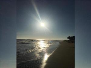 a beach with the sun shining on the water at Luxury Cabarete East Condominiums in Cabarete