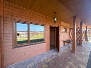 a porch of a house with a window and a bench at Hotel Eliot in Łomża +1 photo