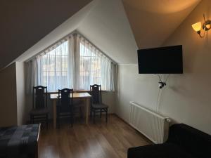 a living room with a table and chairs and a window at Hotel Eliot in Łomża