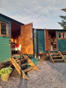 a group of green and blue huts with stairs at Siabod Huts in Betws-y-coed +6 photos