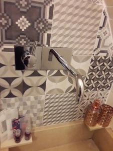a bathroom with a faucet and tiles on the wall at RODRIGUEZ Luxury Suite in Ostuni