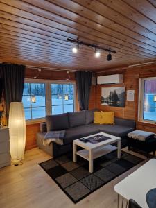 a living room with a couch and a table at Sarvasstugan in Auktsjaur