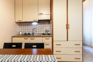 a kitchen with white cabinets and a wooden table at Bed and Breakfast L'Annunziata in Sulmona