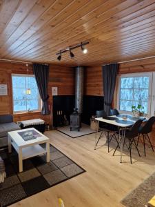 a living room with a wooden ceiling and a table at Sarvasstugan in Auktsjaur