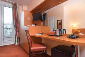 Cette chambre d'hôtel dispose d'un bureau et d'une télévision. dans l'établissement Virgina, à Paris